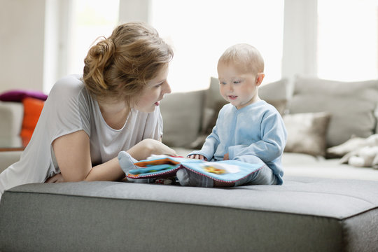 Woman showing a picture book to her daughter