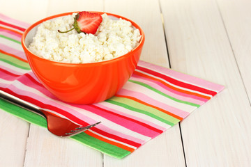 cottage cheese with strawberry in orange bowl and fork