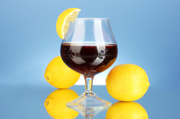 glass of brandy on blue background close-up