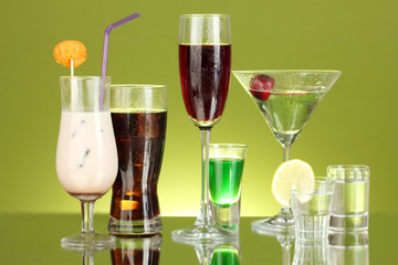 a variety of alcoholic drinks on green background