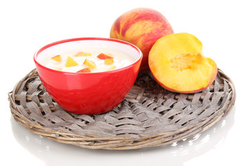 Yoghurt with peach in bowl on wicker mat isolated on white