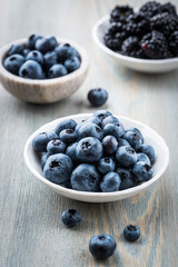 Blueberries and blackberries in small bowls