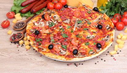 delicious pizza, vegetables and salami on wooden table