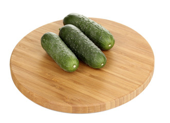 Fresh cucumbers on wooden board isolated on white