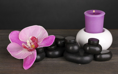 Fototapeta na wymiar Kamienie spa z kwiat orchidei i świeca