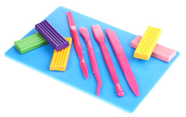 Children bright plasticine on desk with stacks isolated on