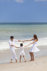 Fototapeta na wymiar Mother, Father & Child Family Playing Having Fun At Beach