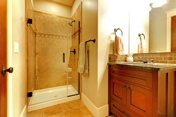 Bathroom with wood cabinet and tile shower.