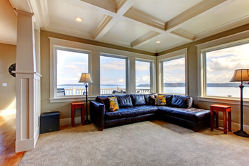 Living room wih many large windows and blue sofa.