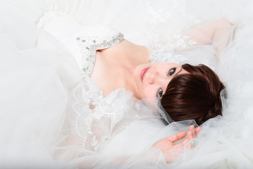 Obraz na płótnie Canvas bride sitting in wedding dress, studio shot