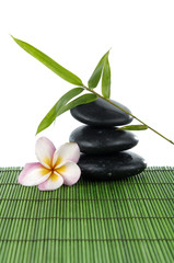 frangipani and zen stones with bamboo leaf on green mat