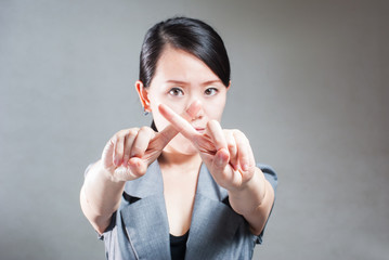 Serious business woman making stop sign over white, focus on han