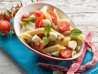 cold pasta salad with slice tomatoes mozzarella and beans