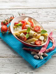 cold pasta salad with slice tomatoes mozzarella and beans