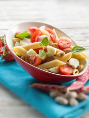 cold pasta salad with slice tomatoes mozzarella and beans