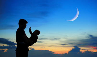 Fototapeta premium Silhouette of father and child on sunset