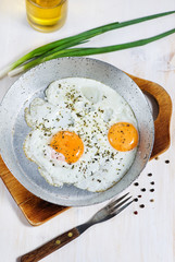 Fried eggs with spice on the frying pan