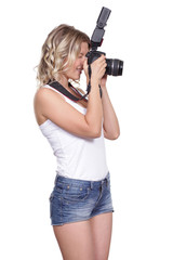 Cheerful woman shooting with a camera against white background