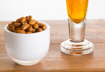 Bowl of raw almond nuts on wooden table