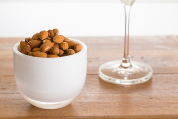 Bowl of raw almond nuts on wooden table
