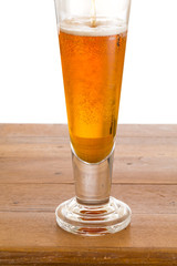 Glass of cold golden beer on wooden bar
