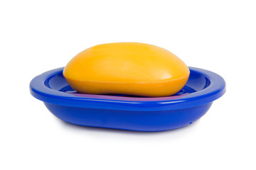 Soap of yellow color in a dark blue soap tray