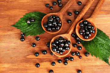 Fresh black in wooden spoons on wooden background close-up