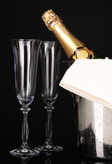 Champagne bottle in bucket with ice and glasses isolated
