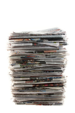 Large stack of newspapers piled on white background
