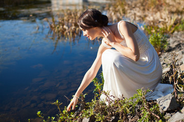 Young woman sitting by water