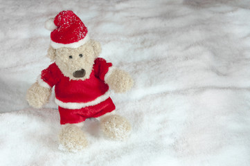 teddy bear in christmas clothes in the snow