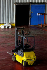 Yellow forklift parked in modern factory warehouse