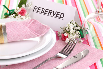 Table setting with reserved card in restaurant