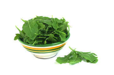 Un bol de roquette sur fond blanc
