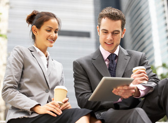 Businessman And Businesswoman Using Digital Tablet Outside Offic