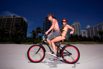 Young couple on Miami Beach Riding bikes and having fun