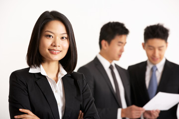 Studio Shot Of Chinese Businesspeople Discussing Document