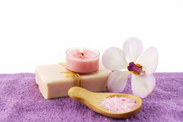 Obraz na płótnie Canvas pink towel background of soap and orchid salt in spoon