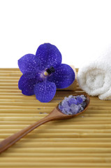 Blue orchid with towel sea salt in spoon on mat