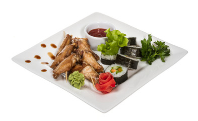 Buffalo chicken wings on plate with sushi