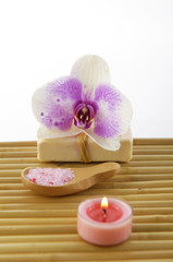 Spa resort-orchid on soap, salt in spoon ,candle on mat