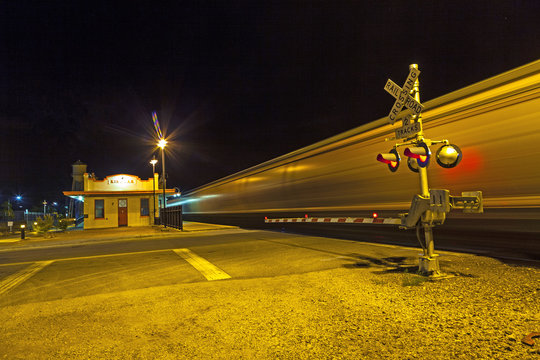 train passes at railroad crossing in the night