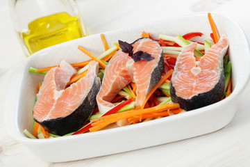 Raw salmon steaks with vegetables