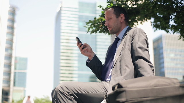 Young handsome businessman with smartphone in the city