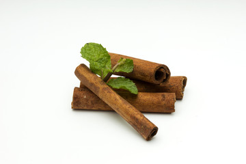 Sticks of cinnamon with mint and anise on a white background