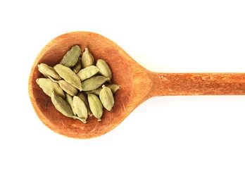 Gordijnen green cardamom in wooden spoon on white background close-up © Africa Studio