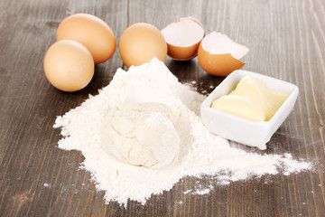 Eggs, flour and butter close-up on wooden table