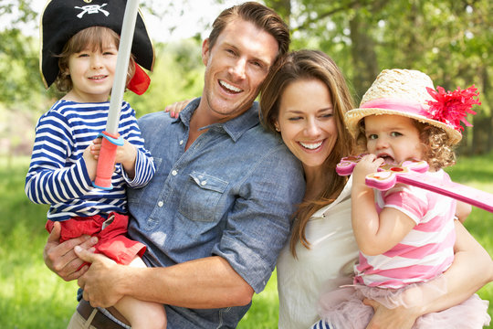 Parents Playing Exciting Adventure Game With Children In Summer