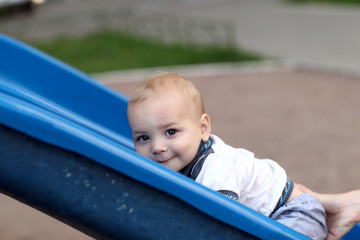 Fototapeta na wymiar Child climbing up slide