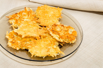 Potato pancakes on transparent plate on table